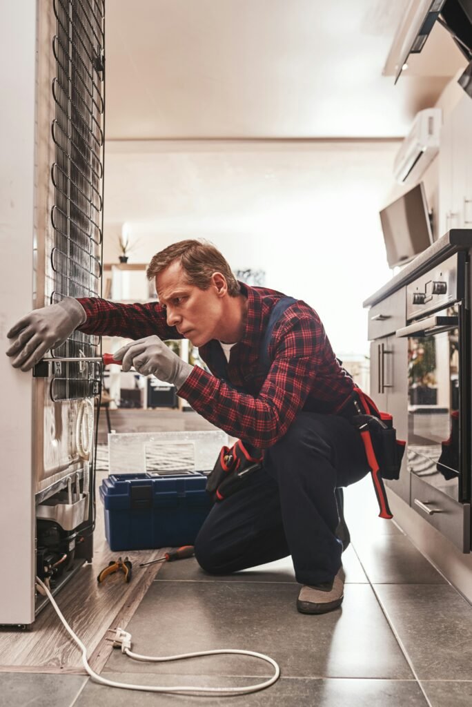 Appliance repair technician fixing refrigerator in vancouver washington